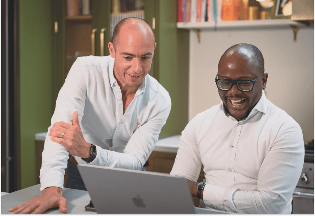 Two men looking at a laptop