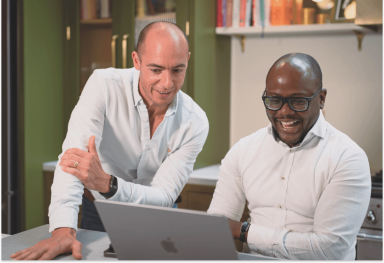 Two men looking at a laptop